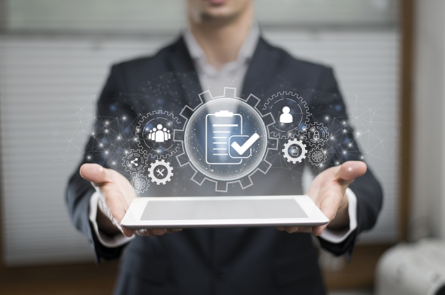 Business professional holding a tablet with client database concept graphics.