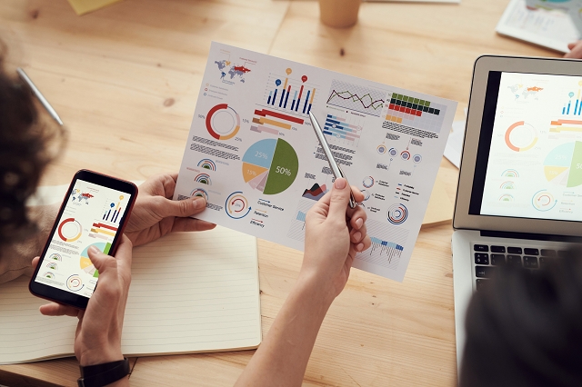 People analyzing marketing data on various devices.