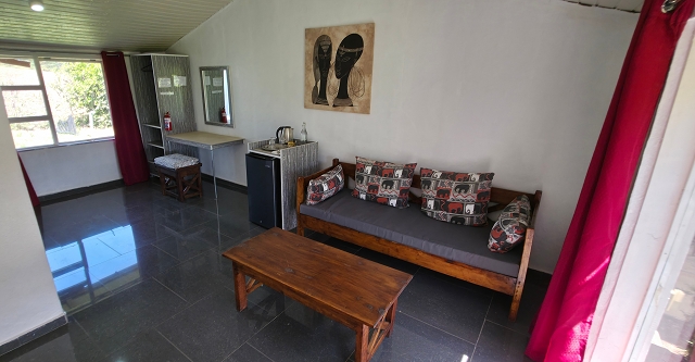 bright room with couch, fridge wardrobe. table windows 2 side